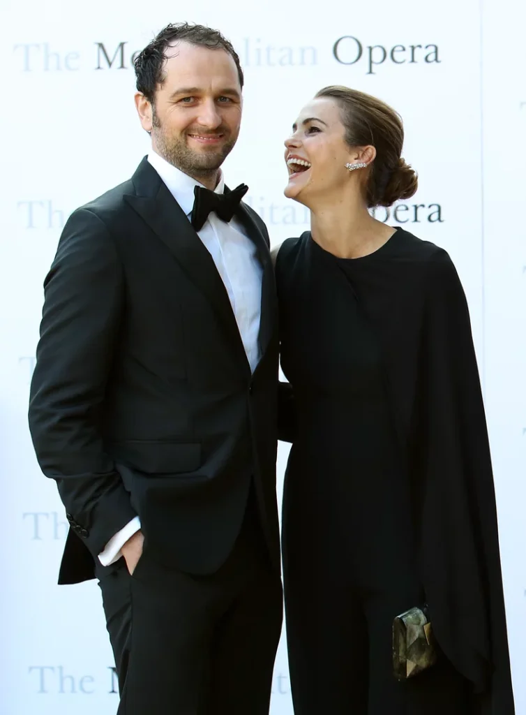 Keri Russell and Matthew Rhys pose together at the Metropolitan Opera, with Rhys wearing a black tuxedo and Russell wearing a black evening outfit.
