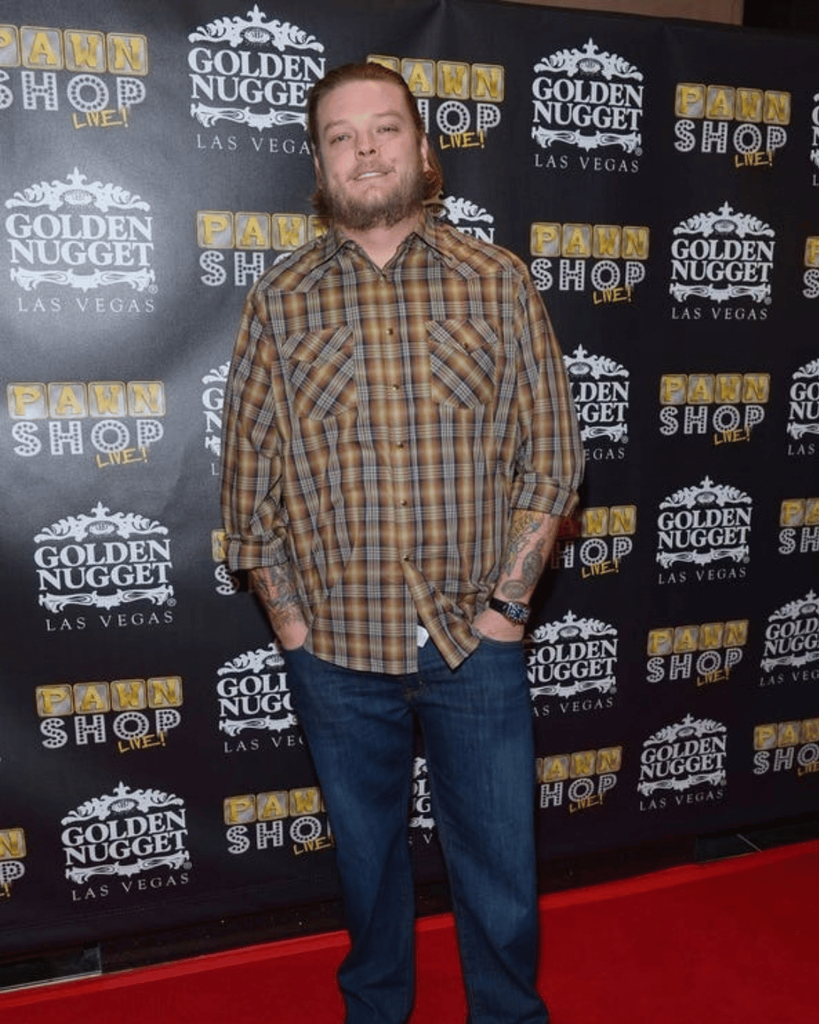 Adam Harrison posing in a plaid shirt at a Pawn Stars event
