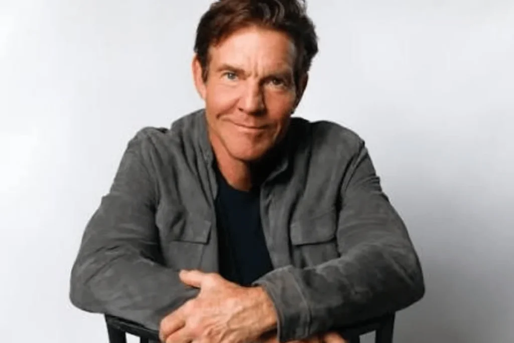 Dennis Quaid posing for a portrait in a gray jacket