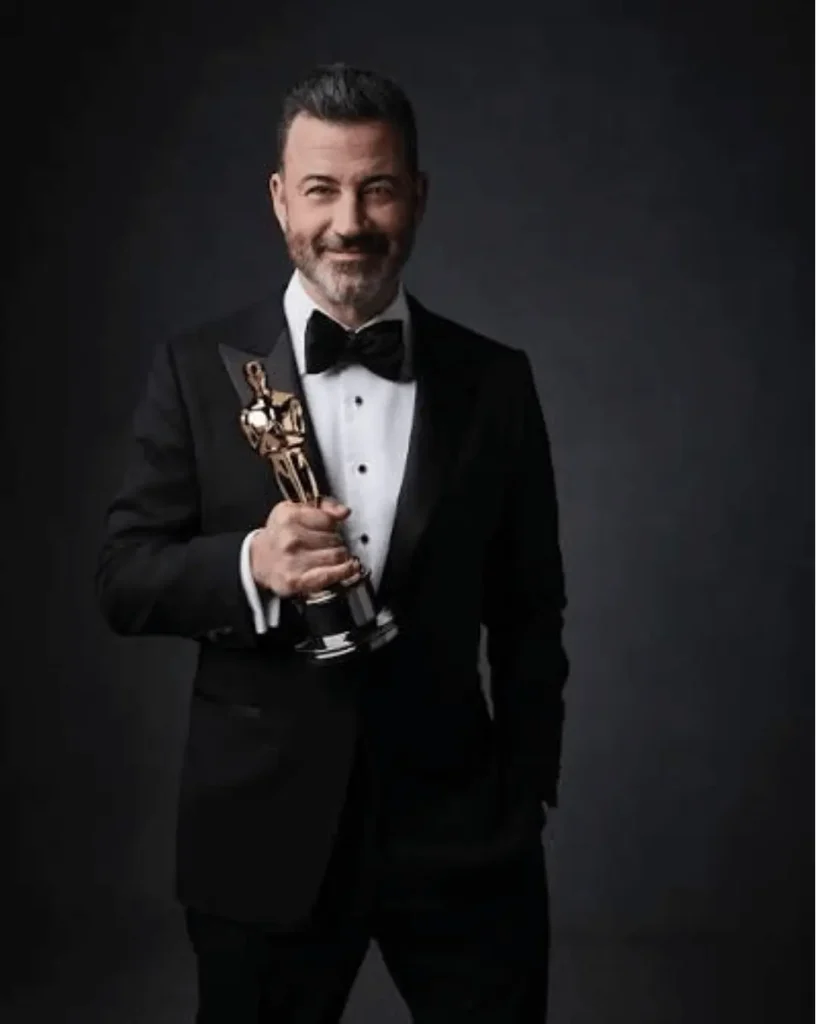 Jimmy Kimmel holding an Oscar award during his entertainment career achievements
