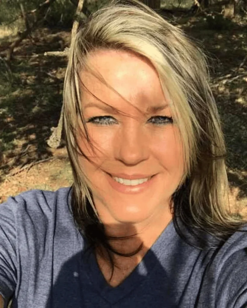 Close-up portrait of Kaynette Williams outdoors with blonde and dark-highlighted hair smiling at the camera.