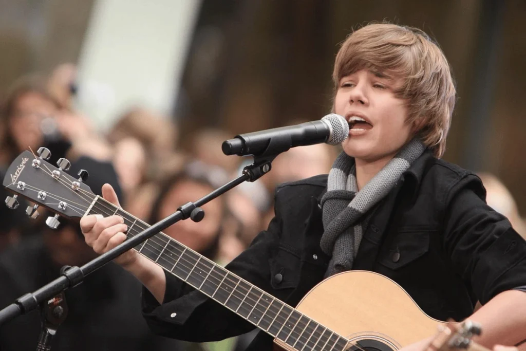 Young Justin Bieber performing with an acoustic guitar in 2009.
